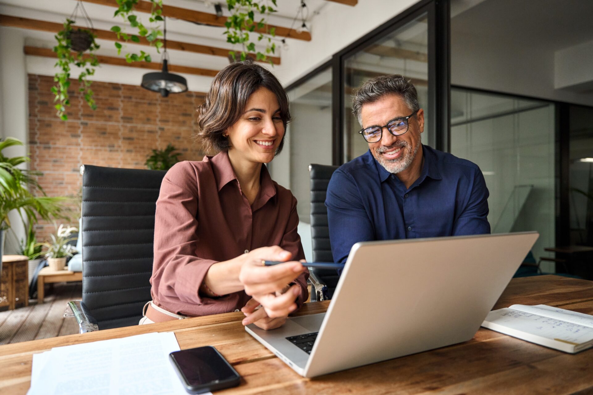 Business,Team,Of,Two,Executives,Working,Together,Using,Laptop,In