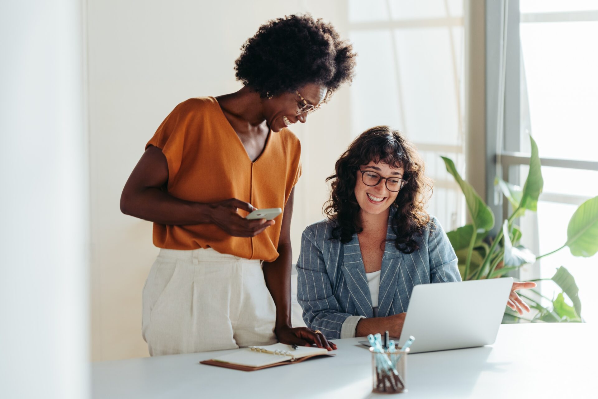 Happy,Professional,Women,Collaborating,With,Enthusiasm,In,A,Modern,Office