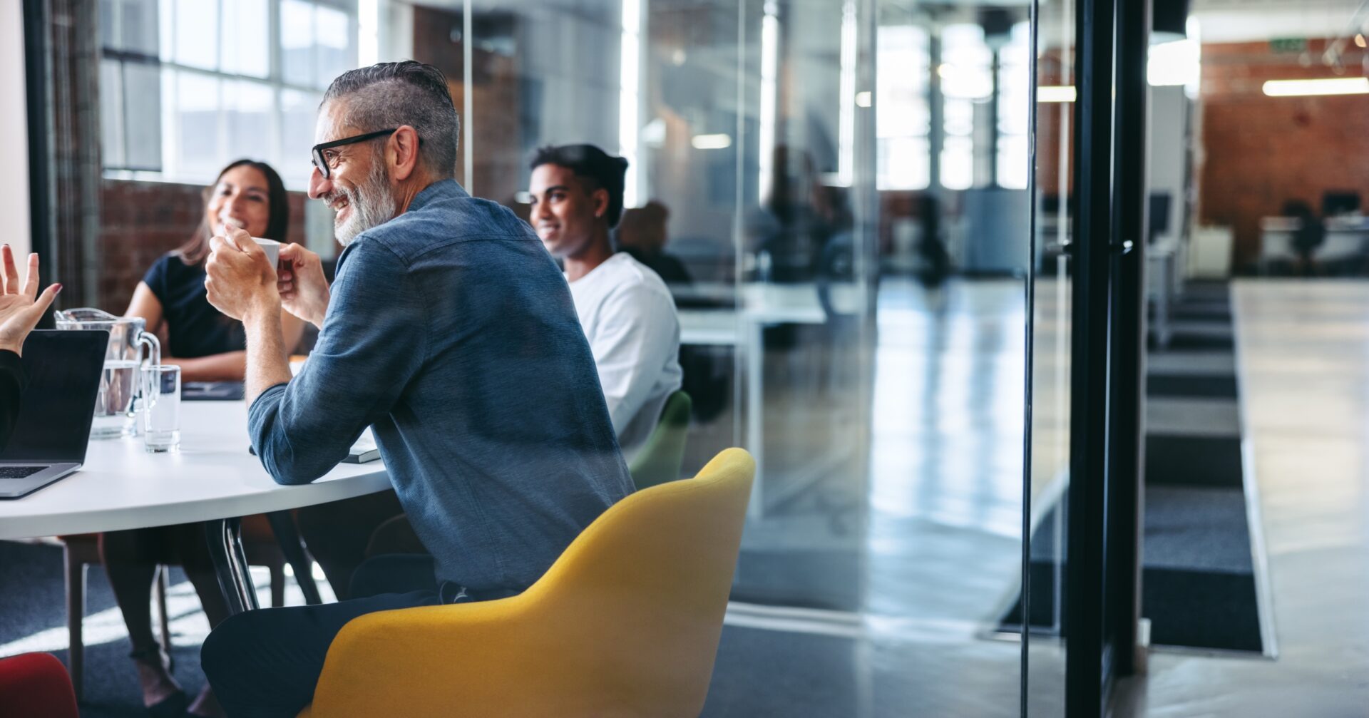 Cheerful,Mature,Businessman,Attending,A,Meeting,With,His,Colleagues,In